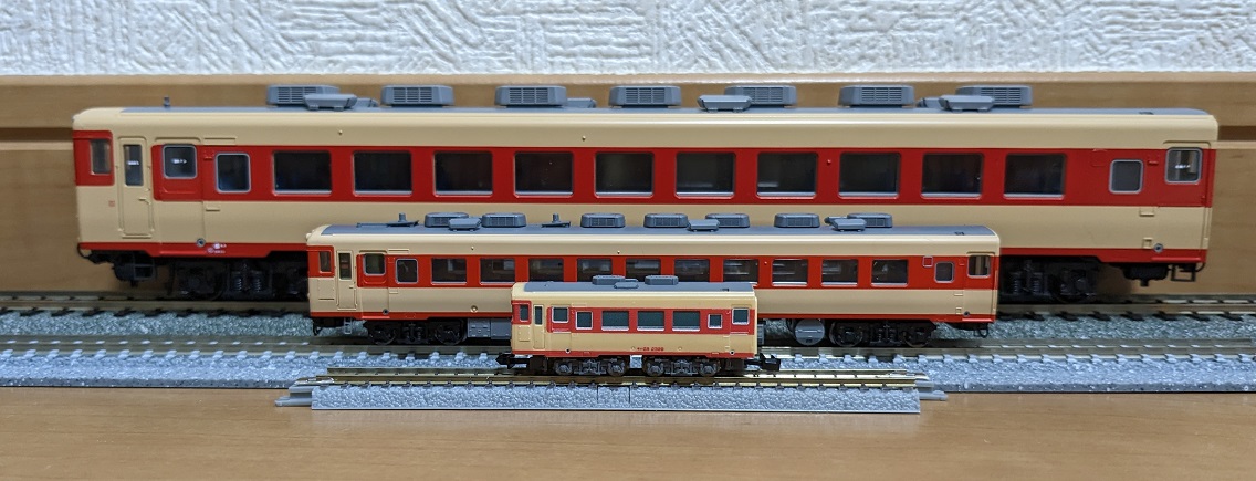 Three models of the same Japanese KiHa 28 diesel railcar side by side, from largest to smallest: HO, N and Z